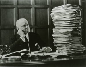 man_looking_at_stack_of_papers